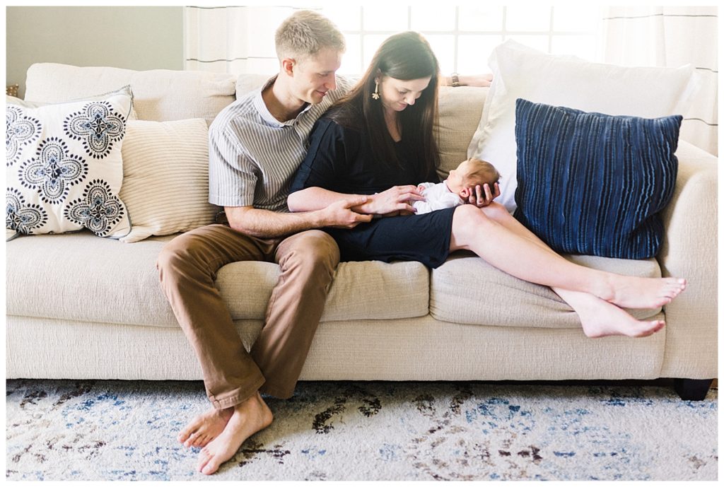 couple looking at newborn on couch