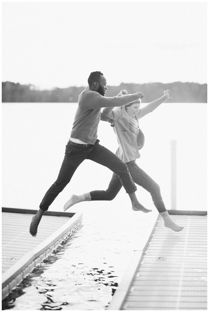couple jumping from a pier