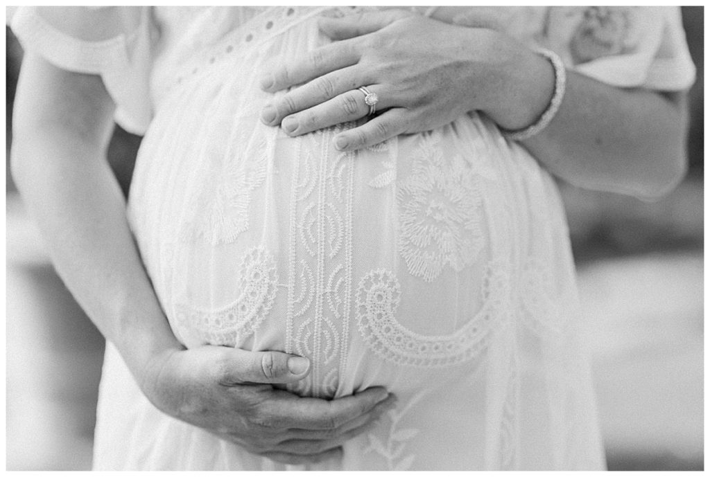 black and white image of pregnant mother holding belly