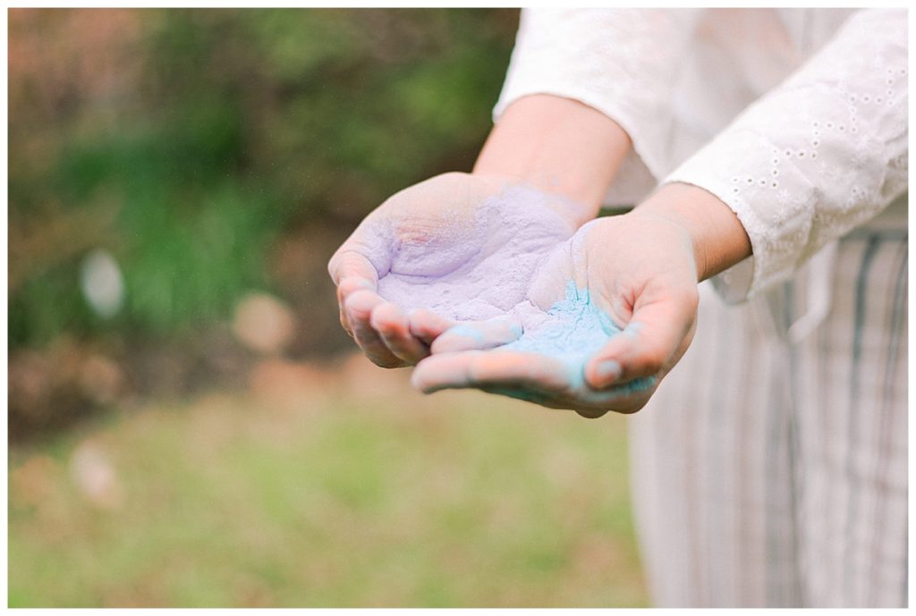 puple and blue holi powder in woman's hands