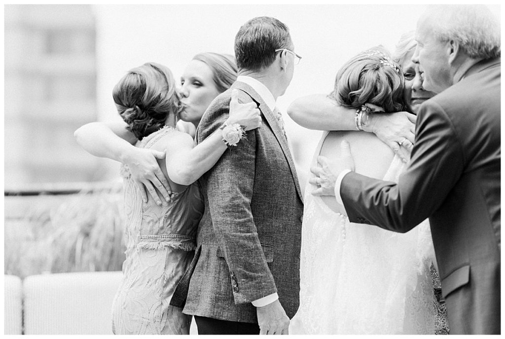 family hugging at wedding at the durham hotel black and white