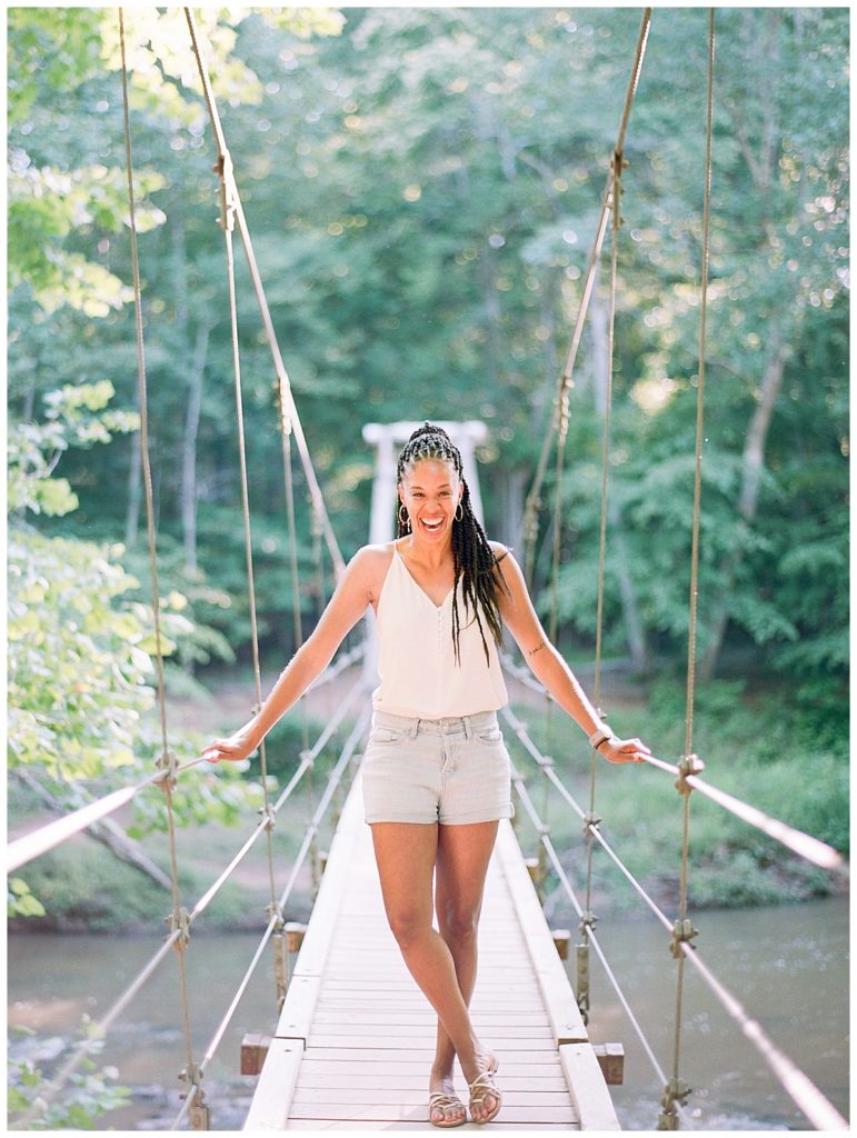 woman standing on hanging bridge at eno river state park