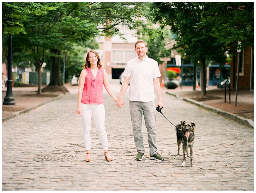 couple standing on cobblestone street at city market