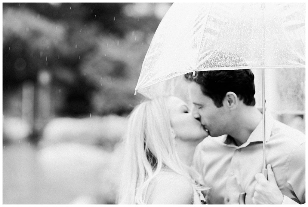 engagement session couple kissing in the rain