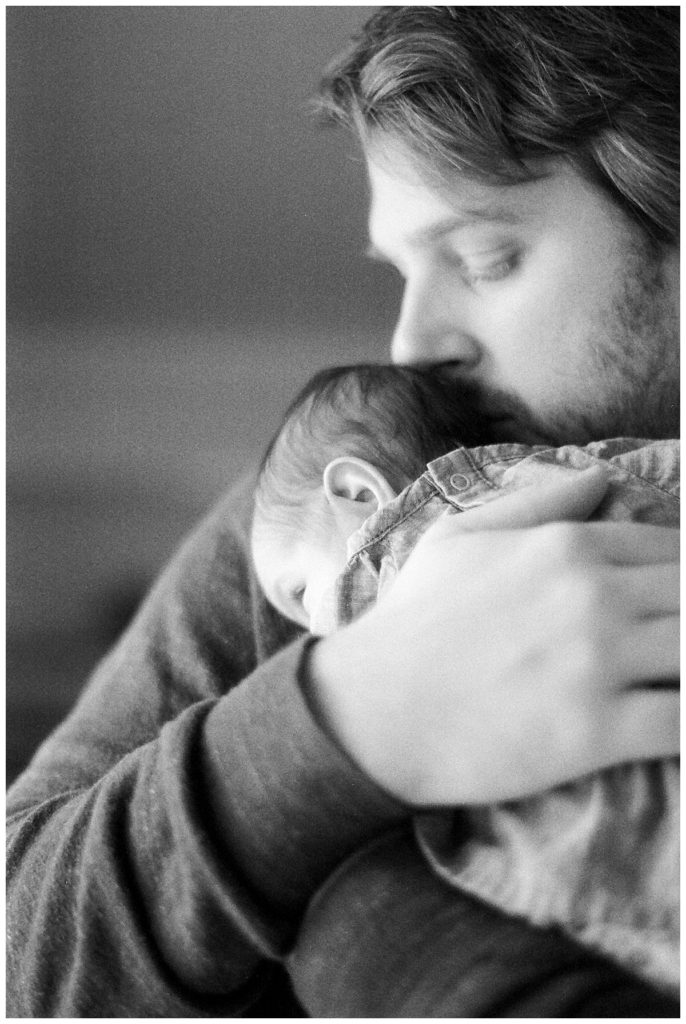 dad snuggling newborn