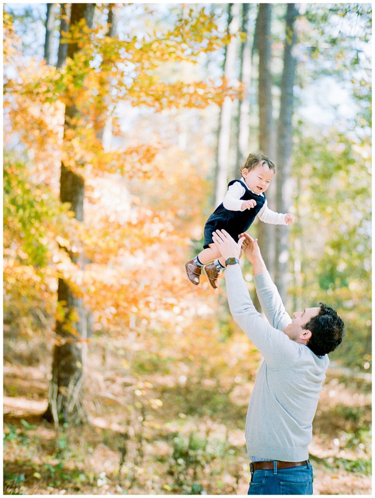 baby boy being thrown into air by dad