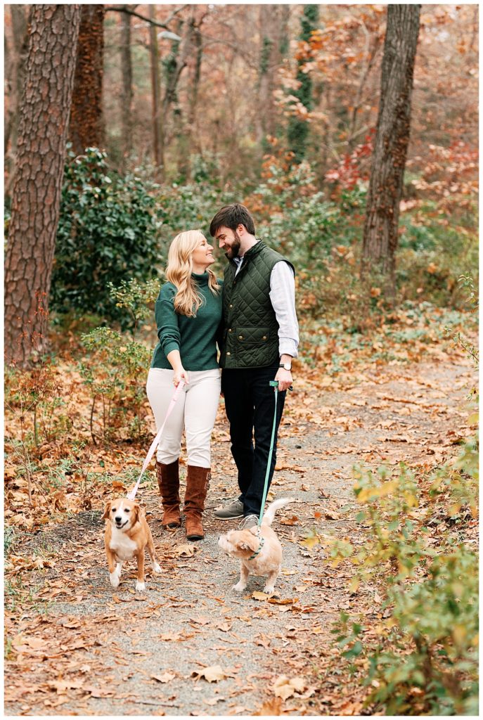 couple walking with dogs engagement