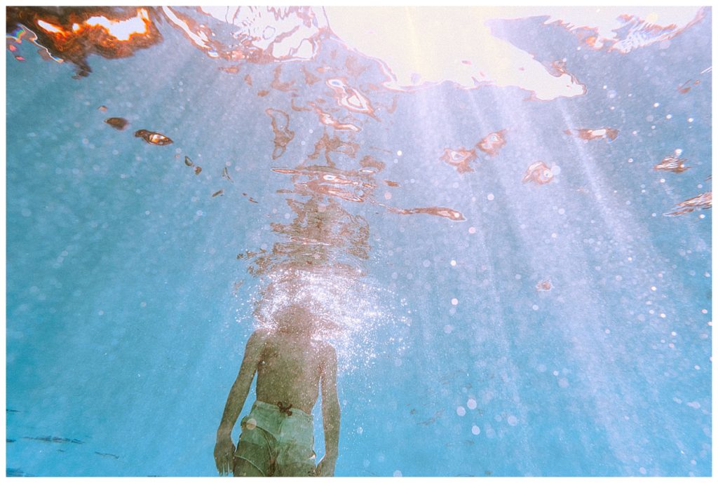 boy swimming underwater hotel pool