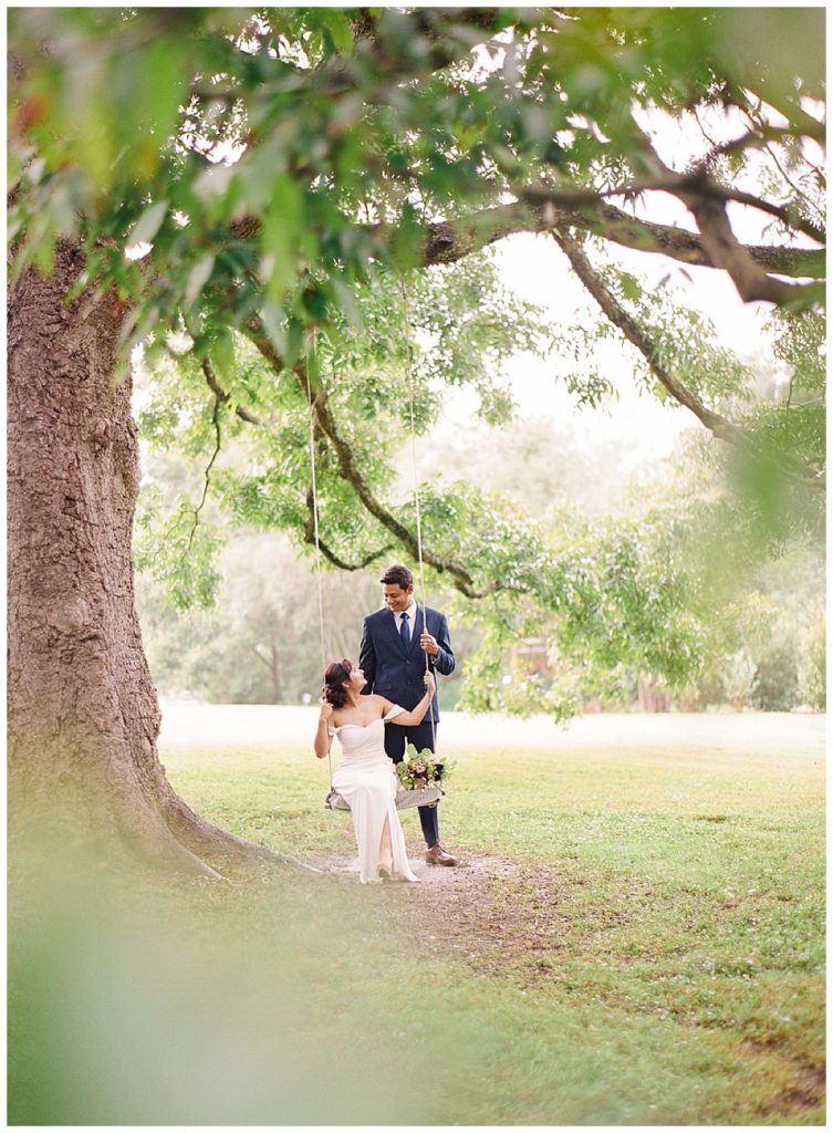 bride and groom in tree swing