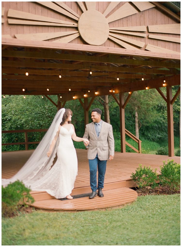 bride and groom walking off of pavilion