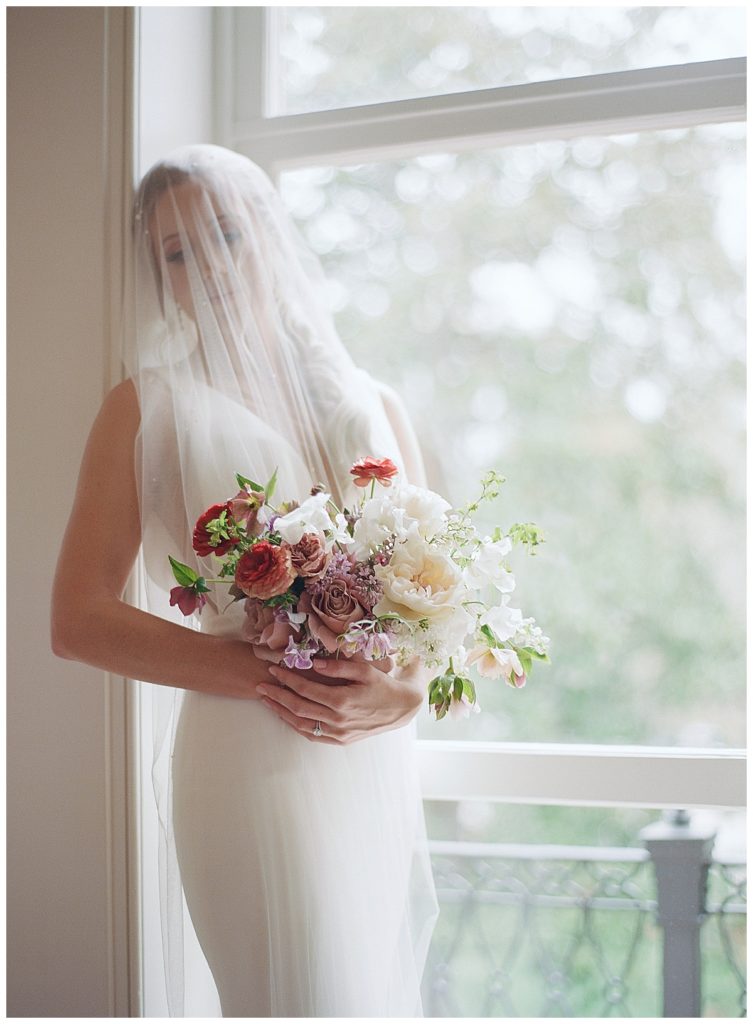 Veiled bride holding bouquet
