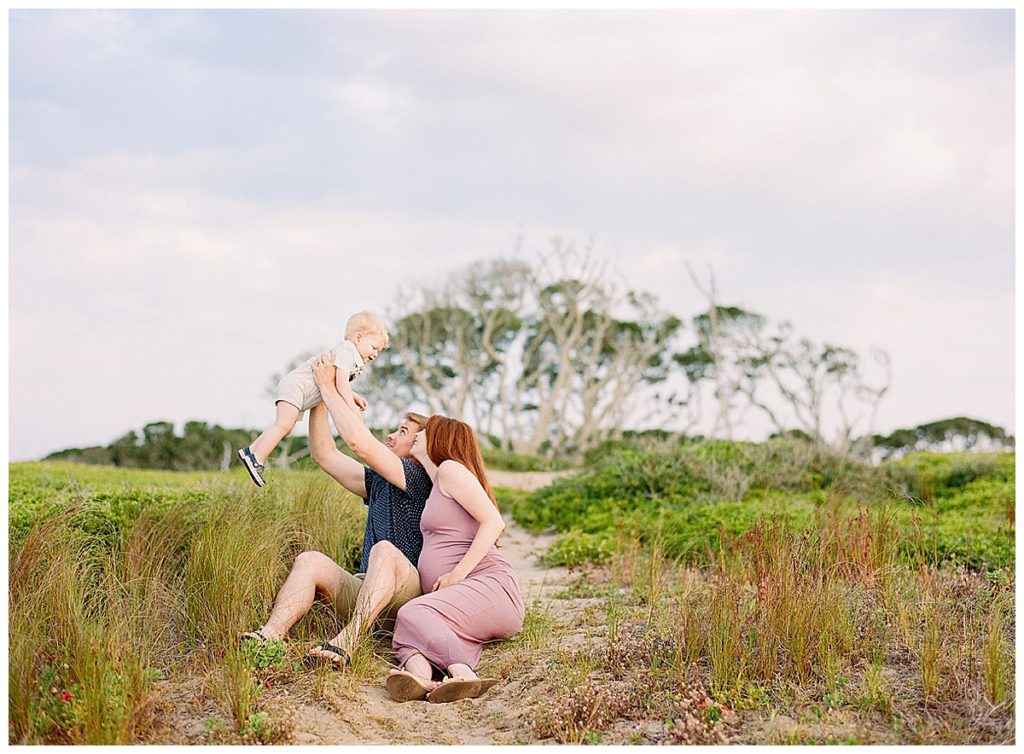 Family playing in the dunes at beach