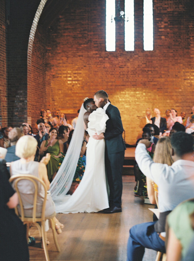 Medium format film photograph captured by NC wedding photographer of a bride and groom's first kiss at the altar.