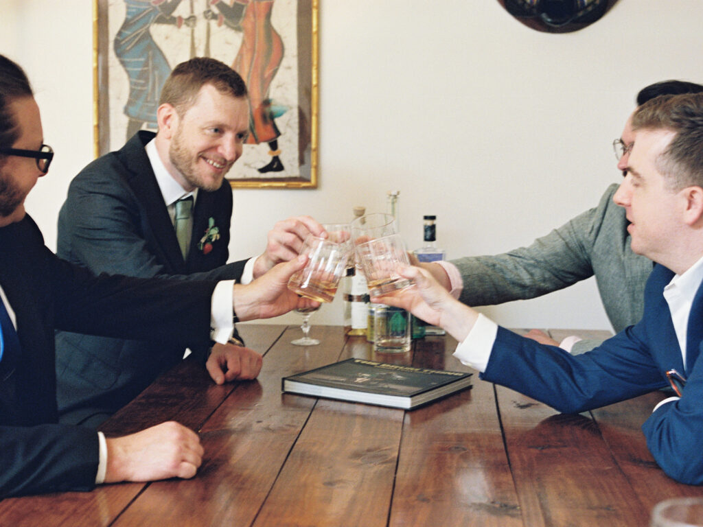 groom cheering with groomsmen on wedding day